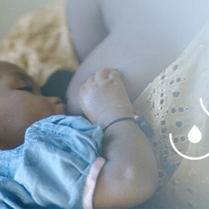 Boleče dojke med dojenjem – mama doji dojenčka in išče udoben položaj za lajšanje bolečin