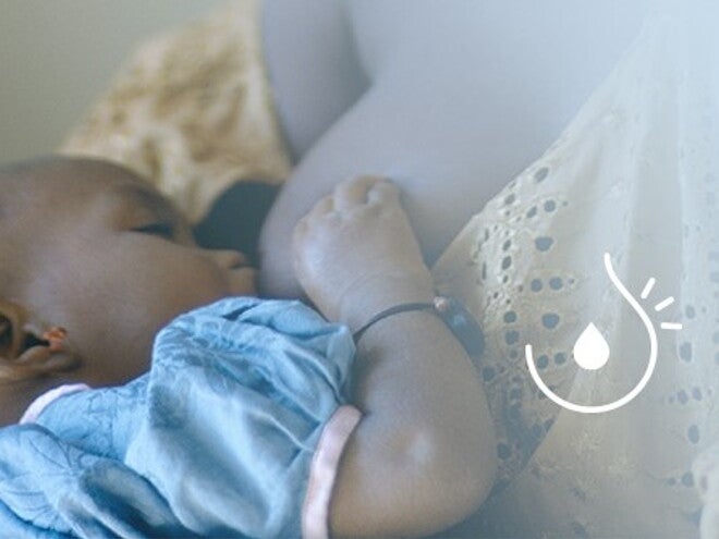 Boleče dojke med dojenjem – mama doji dojenčka in išče udoben položaj za lajšanje bolečin